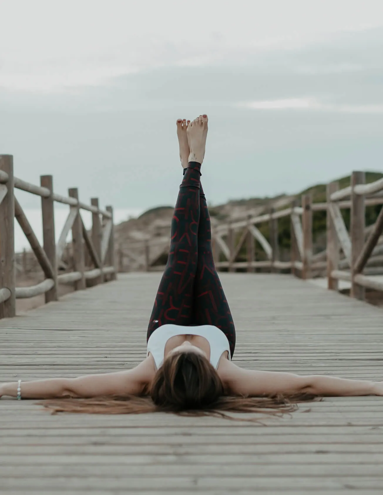 woman with legs up on pier